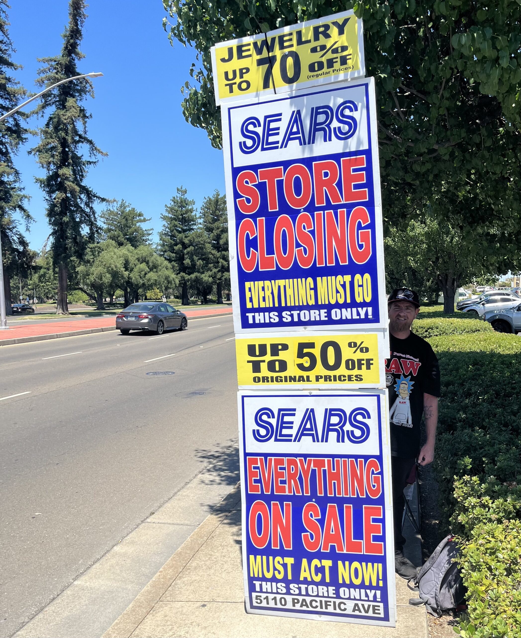 A Sears worker displays a sign on the side of the road reminding drivers everything must go. A Sears worker displays a sign on the side of the road reminding drivers everything must go.